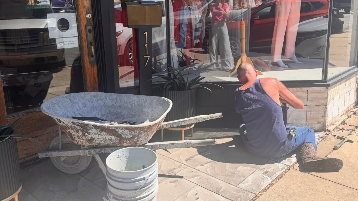 Downtown improvement work taking place outside a historic storefront in Harrison, Arkansas.