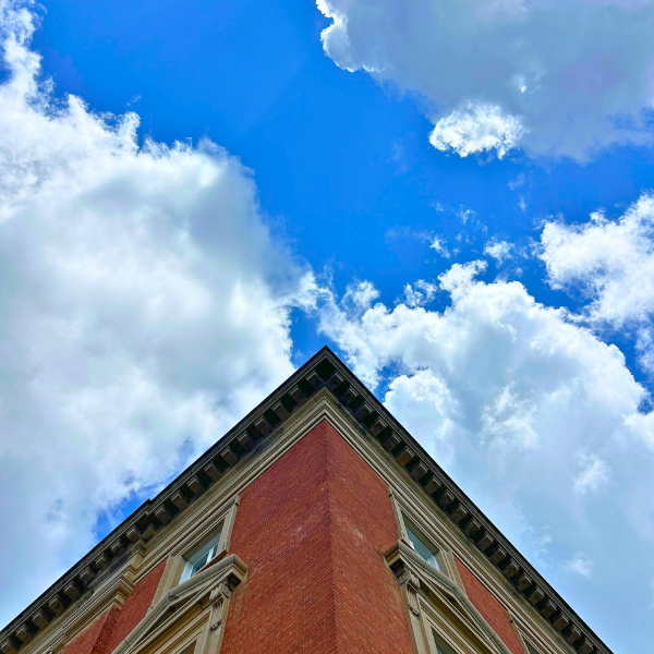 Historic brick architecture on the Old Federal Building in downtown Harrison, Arkansas, viewed from below against a bright blue sky.
