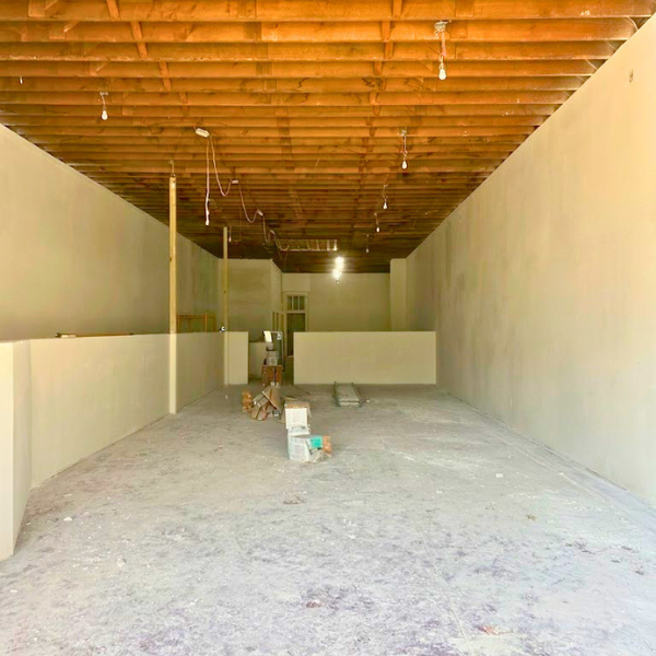 Historic brick building under renovation in downtown Harrison, Arkansas, showing progress on a future business location.