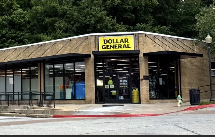 Exterior of the Bennett Building on the downtown Harrison square, showing the Dollar General storefront, black awnings, large windows, entrance ramp and brick facade.