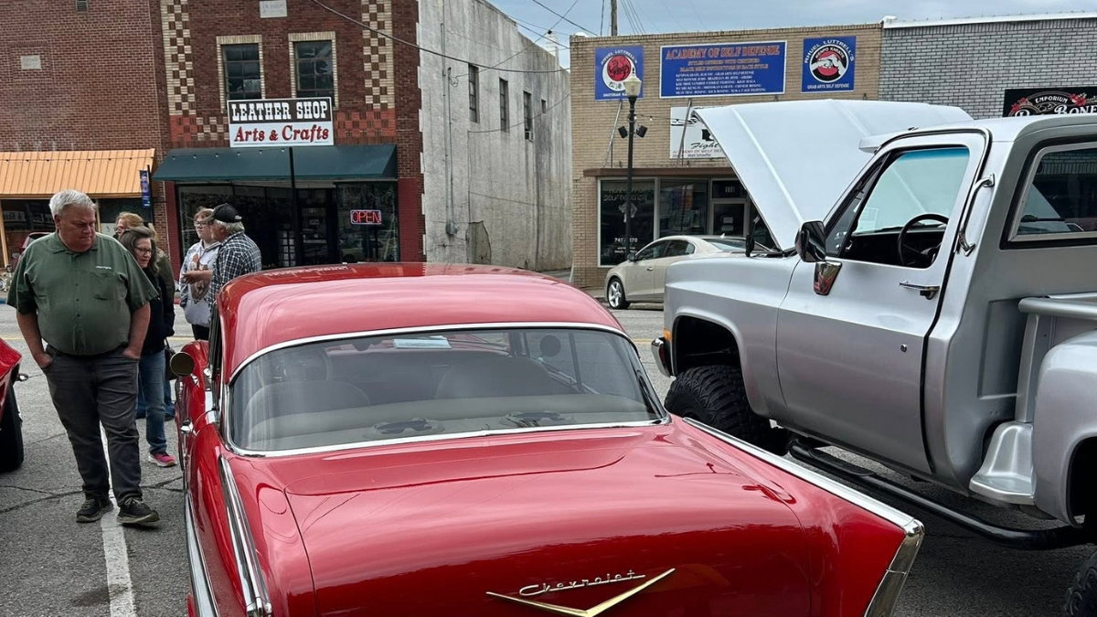 Visitors explore classic cars during the Rev Up Main Street Car Show in downtown Harrison, Arkansas.
